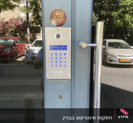 מערכת אינטרקום על דלת זכוכית עם מדבקה